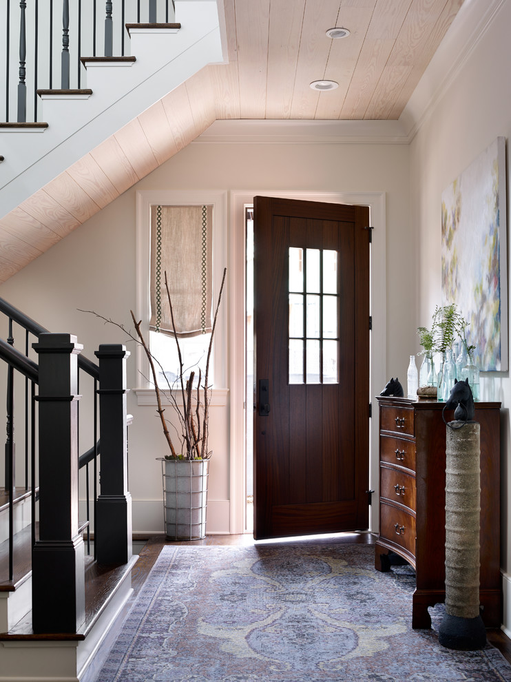 Example of a mid-sized transitional medium tone wood floor and brown floor entryway design in Other with white walls and a dark wood front door