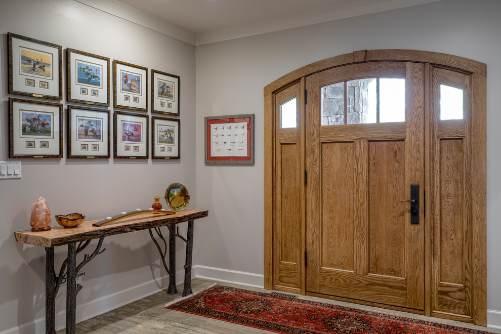 Idee per una porta d'ingresso country di medie dimensioni con pareti marroni, pavimento in legno massello medio, una porta singola, una porta in legno bruno e pavimento marrone