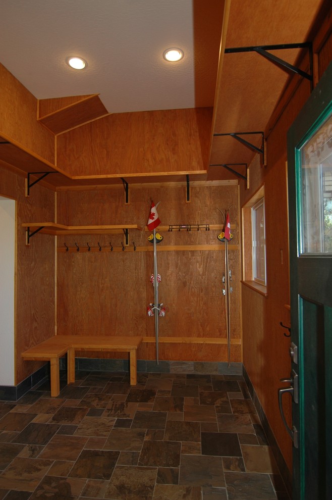 Inspiration för mellanstora amerikanska kapprum, med bruna väggar, skiffergolv, en enkeldörr och en grön dörr