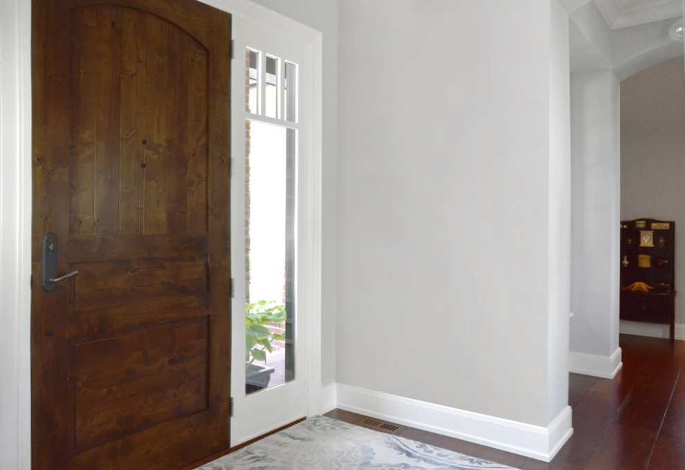 Ispirazione per un piccolo ingresso classico con pareti grigie, parquet scuro, una porta singola, una porta in legno bruno e pavimento marrone