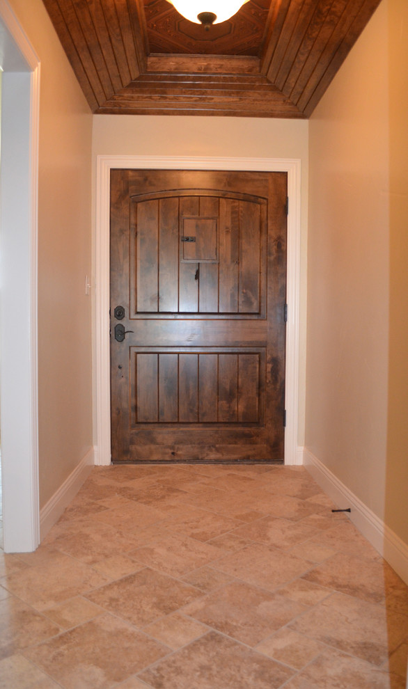 Esempio di una piccola porta d'ingresso tradizionale con pareti beige, pavimento con piastrelle in ceramica, una porta a pivot, una porta in legno scuro e pavimento beige
