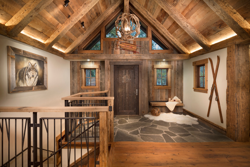 Idées déco pour un hall d'entrée montagne de taille moyenne avec un mur beige, une porte simple, une porte en bois foncé et un sol en bois brun.