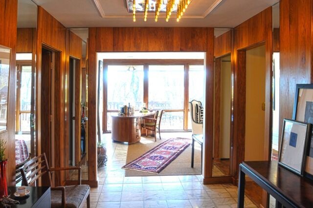 ルイビルにあるラグジュアリーな広いミッドセンチュリースタイルのおしゃれな玄関ロビー (大理石の床、木目調のドア) の写真