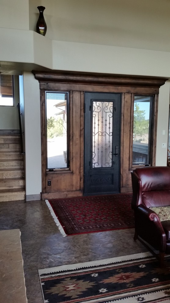 Foto di una grande porta d'ingresso stile rurale con pareti beige, pavimento in cemento, una porta singola e una porta in legno scuro