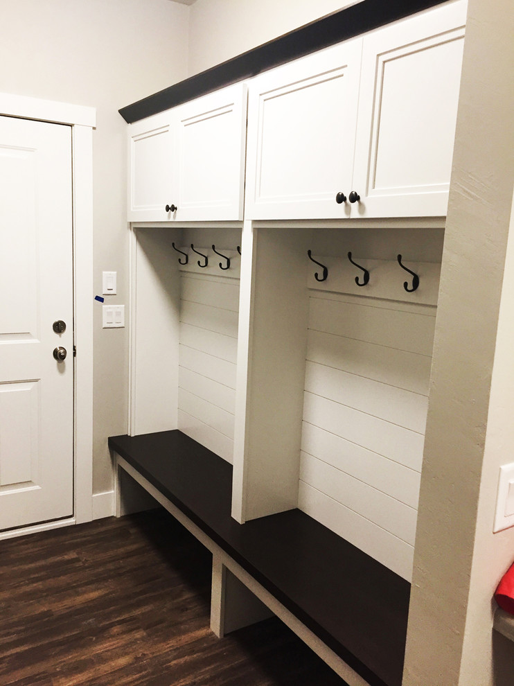 На фото: тамбур среднего размера со шкафом для обуви в стиле кантри с белыми стенами, темным паркетным полом, одностворчатой входной дверью и белой входной дверью