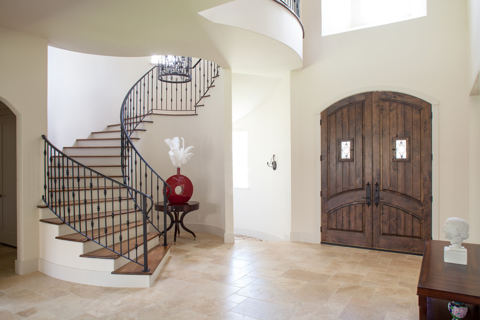 Modelo de puerta principal clásica grande con paredes blancas, puerta doble, puerta de madera oscura, suelo beige y suelo de travertino