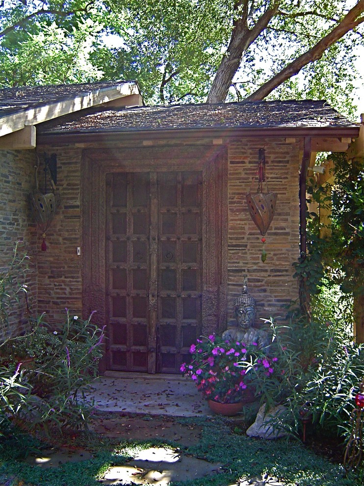 This is an example of a medium sized world-inspired front door in Los Angeles with multi-coloured walls, concrete flooring, a single front door and a dark wood front door.