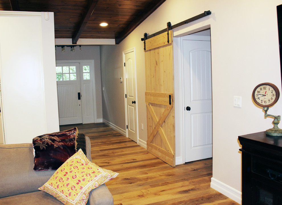 Immagine di un ingresso o corridoio american style di medie dimensioni con pareti bianche, pavimento in legno massello medio, una porta a pivot e una porta bianca