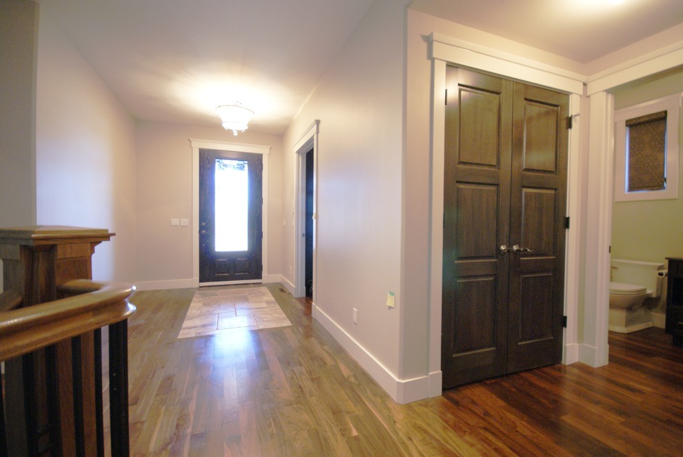 Design ideas for a medium sized traditional hallway in Calgary with beige walls, medium hardwood flooring and a single front door.