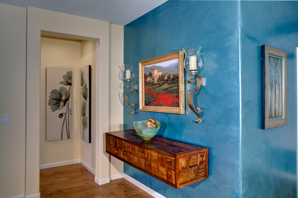 Foto de entrada actual de tamaño medio con paredes azules y suelo de madera en tonos medios