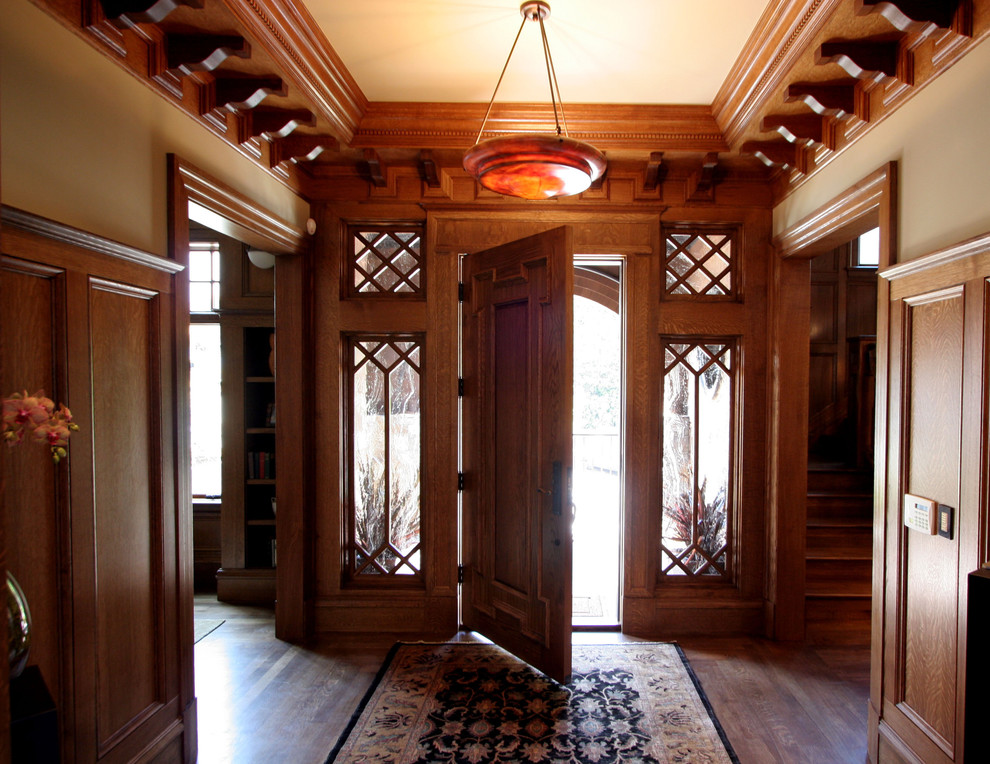 Idées déco pour une porte d'entrée craftsman avec un mur beige, parquet foncé, une porte simple et une porte en bois brun.