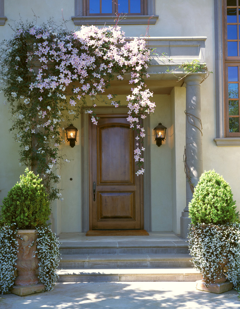 Example of a tuscan entryway design in San Francisco with a medium wood front door