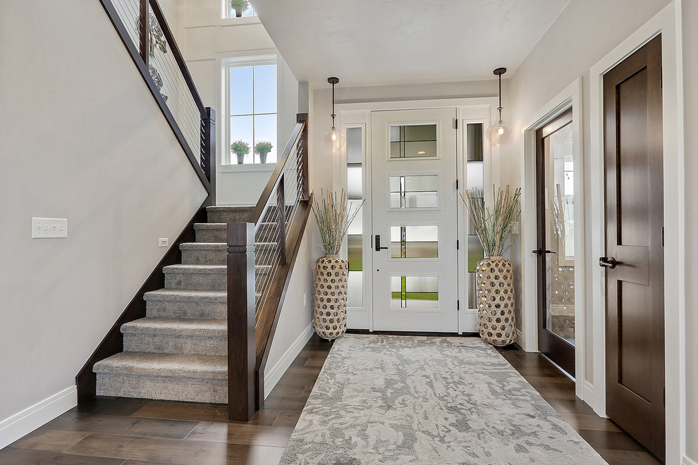 Beach style medium tone wood floor and brown floor entryway photo in Other with gray walls and a white front door