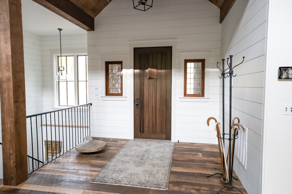 Idee per un ingresso country con pareti bianche, pavimento in legno massello medio, una porta singola e una porta in legno bruno
