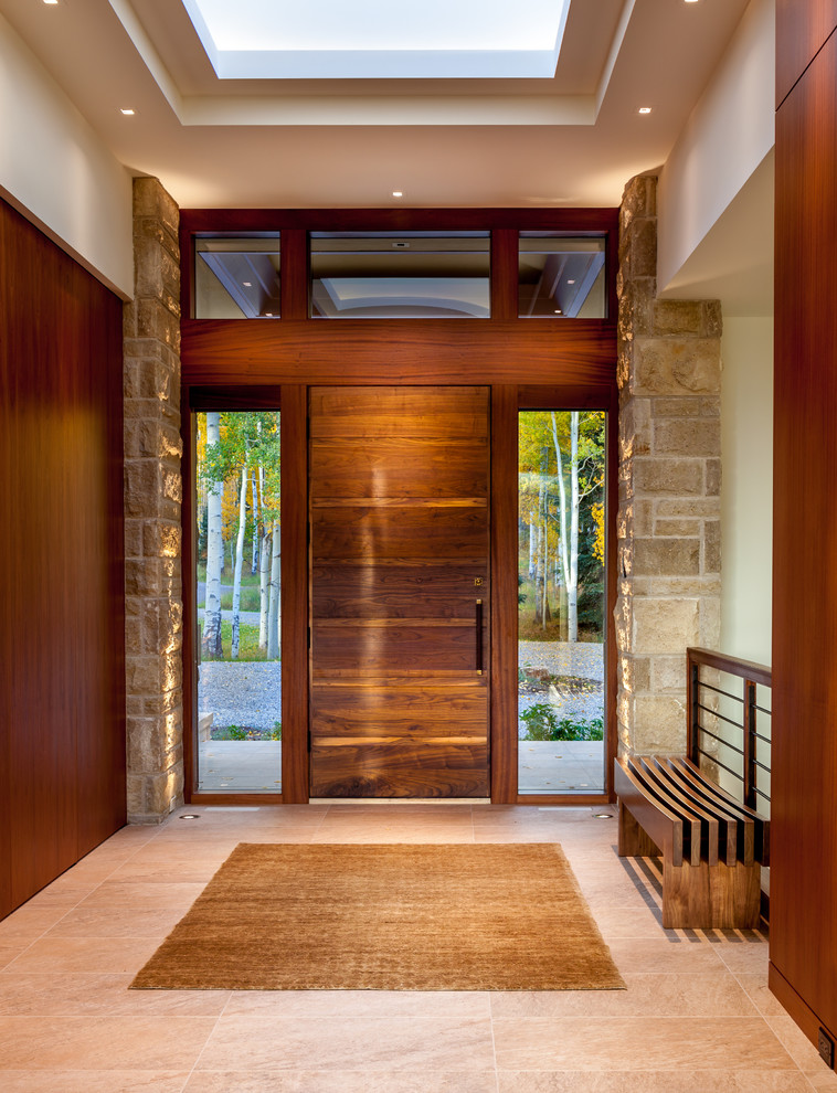 Esempio di un ingresso minimal con pareti bianche, una porta singola, una porta in legno bruno e pavimento beige