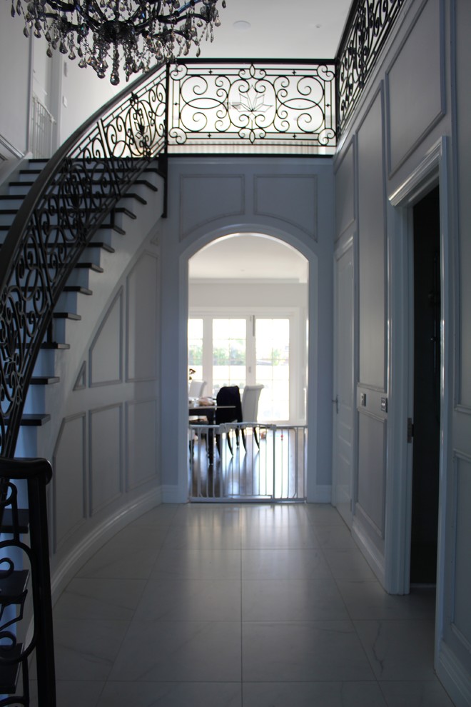 Foto di un grande ingresso classico con pareti grigie, pavimento in gres porcellanato, una porta a due ante e una porta nera