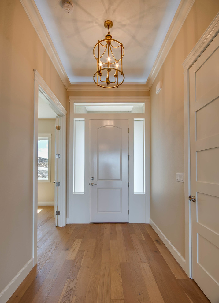 Foto de hall clásico renovado pequeño con paredes beige, puerta simple, puerta blanca y suelo de madera clara