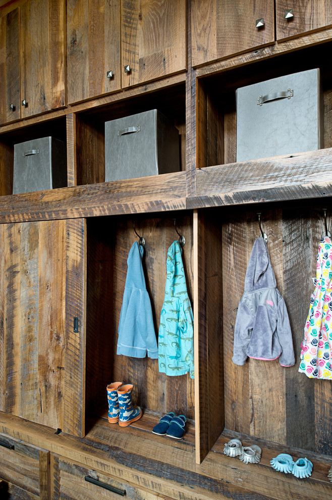 Inspiration for a mid-sized rustic mudroom remodel in Other with white walls