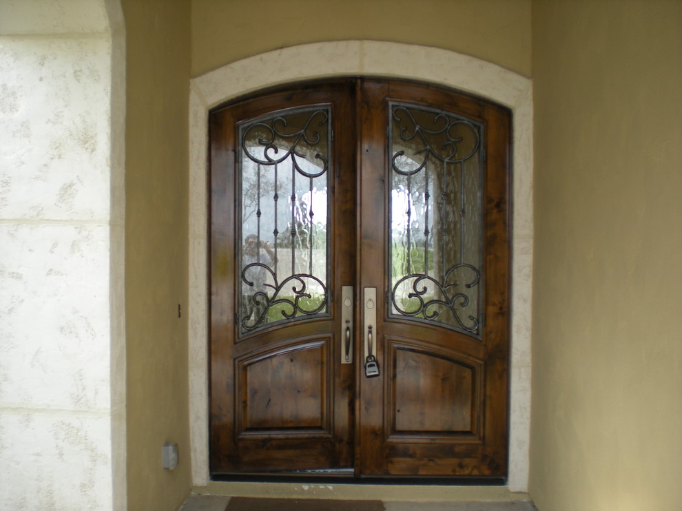 Exemple d'une grande porte d'entrée chic avec un mur beige, une porte double et une porte en bois brun.