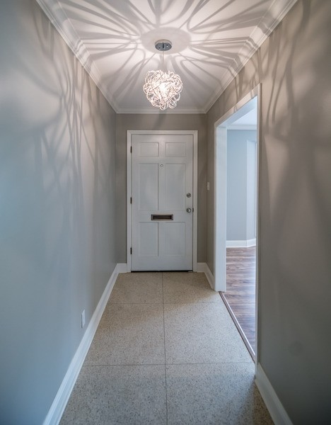 ニューオリンズにあるトランジショナルスタイルのおしゃれな玄関ロビー (テラゾーの床、白いドア) の写真