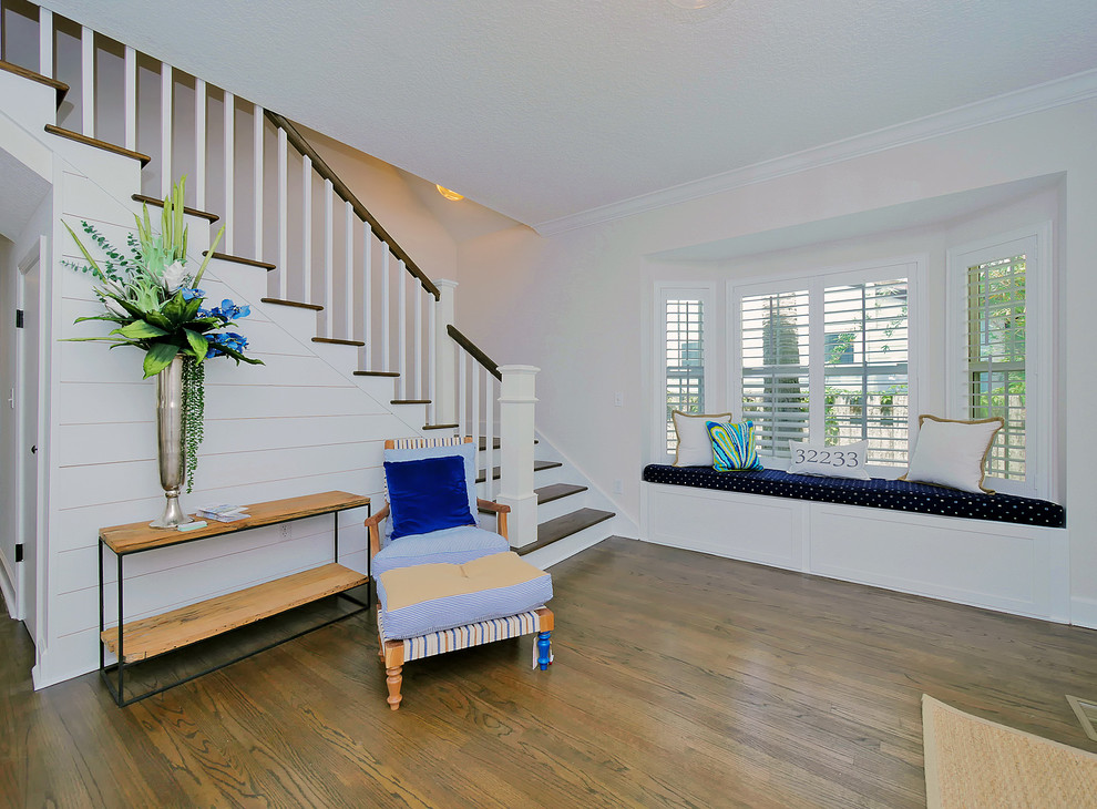 Example of a mid-sized beach style medium tone wood floor and brown floor entryway design in Jacksonville with white walls and a green front door
