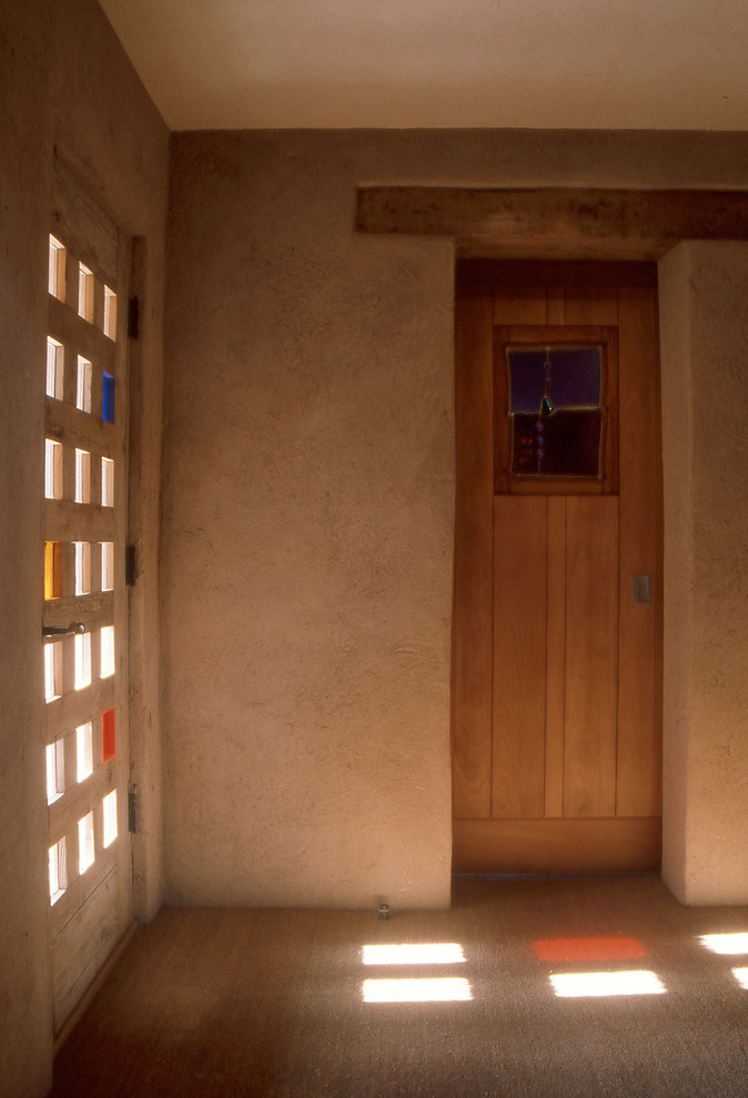 На фото: входная дверь среднего размера в стиле фьюжн с бежевыми стенами, ковровым покрытием, одностворчатой входной дверью и входной дверью из светлого дерева