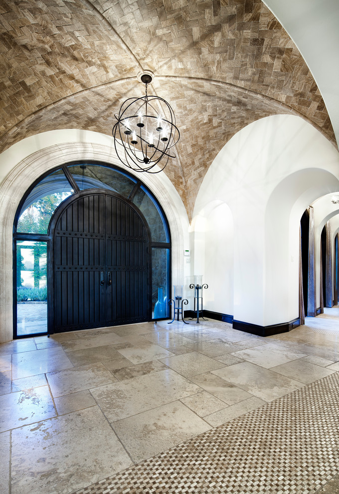 Immagine di un ingresso o corridoio mediterraneo con una porta in legno scuro