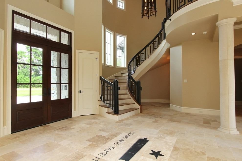Inspiration for an expansive traditional foyer in Houston with travertine flooring, a double front door and a dark wood front door.