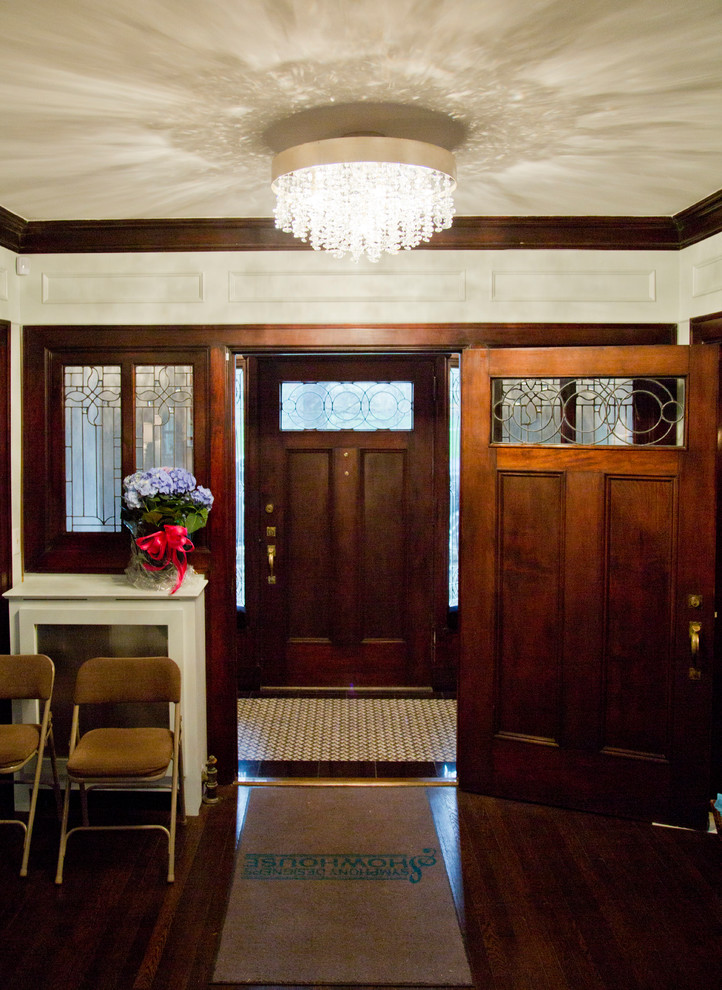 Mittelgroßes Rustikales Foyer mit weißer Wandfarbe, dunklem Holzboden, Einzeltür und dunkler Holzhaustür in Kansas City