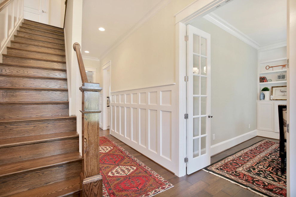 Idee per un corridoio stile americano di medie dimensioni con pareti beige, parquet scuro, una porta a due ante e una porta in legno bruno