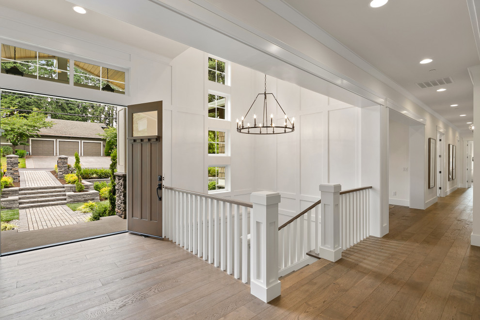 This is an example of a large traditional foyer in Seattle with white walls, medium hardwood flooring, a double front door, a medium wood front door, brown floors, a drop ceiling and wainscoting.