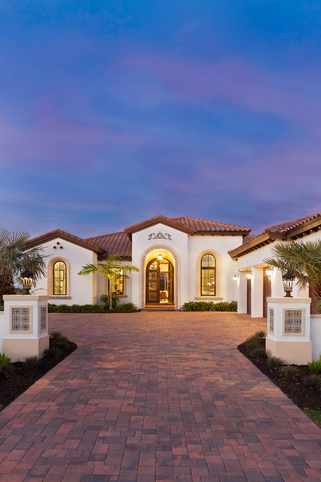 Geräumiger Mediterraner Eingang mit beiger Wandfarbe, Betonboden, Doppeltür, brauner Haustür und buntem Boden in Tampa