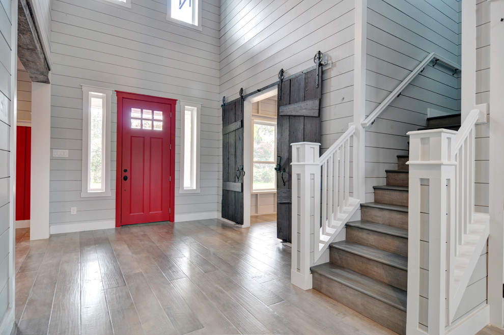 Großes Landhausstil Foyer mit grauer Wandfarbe, hellem Holzboden, Einzeltür und roter Haustür in Dallas