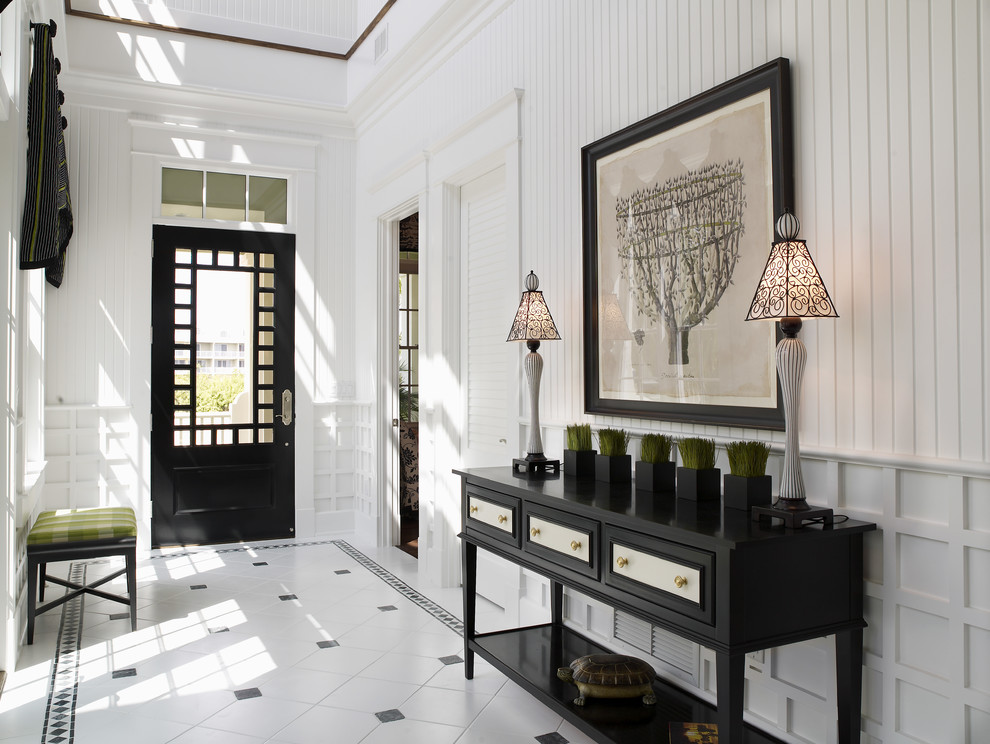 На фото: фойе среднего размера в современном стиле с белыми стенами, полом из керамической плитки, одностворчатой входной дверью, черной входной дверью и белым полом с