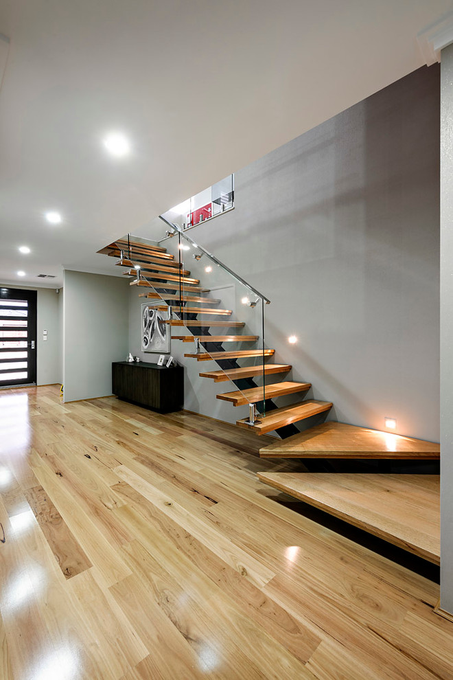 Inspiration for a mid-sized modern light wood floor entryway remodel in Perth with gray walls and a black front door