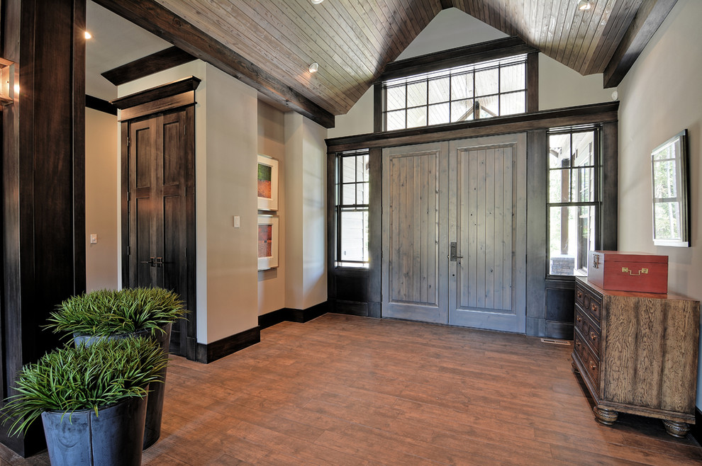 シアトルにあるラグジュアリーな広いトラディショナルスタイルのおしゃれな玄関ロビー (白い壁、無垢フローリング、グレーのドア、茶色い床) の写真