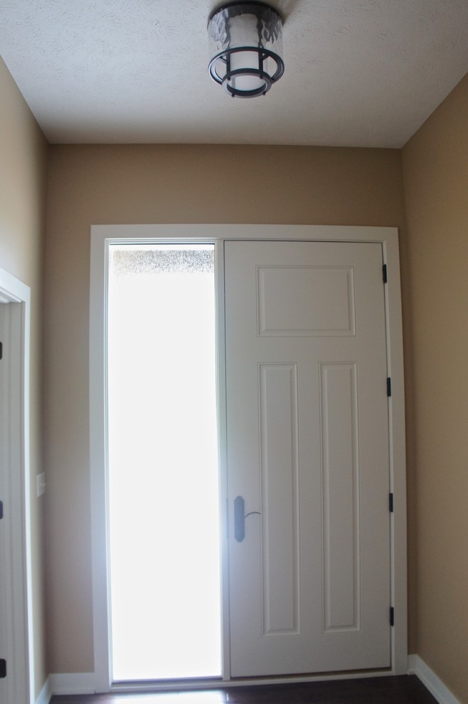Mittelgroßer Uriger Eingang mit Korridor, brauner Wandfarbe, braunem Holzboden, Einzeltür, weißer Haustür und braunem Boden in Sonstige