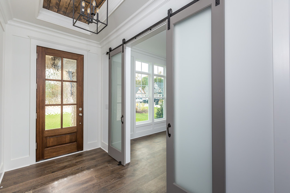 Mittelgroßes Landhausstil Foyer mit weißer Wandfarbe, dunklem Holzboden, Einzeltür, dunkler Holzhaustür und braunem Boden in Raleigh