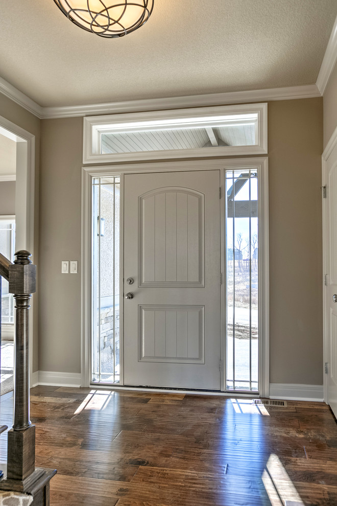 Inspiration pour une porte d'entrée traditionnelle de taille moyenne avec un mur beige, parquet foncé, une porte simple et une porte blanche.