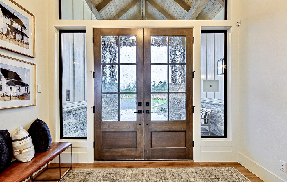 Geräumiges Landhausstil Foyer mit beiger Wandfarbe, hellem Holzboden, Doppeltür, dunkler Holzhaustür und braunem Boden in Portland
