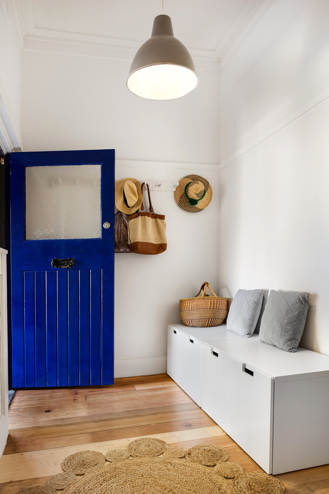 Modernes Foyer mit weißer Wandfarbe, braunem Holzboden, Einzeltür, blauer Haustür und braunem Boden in Melbourne