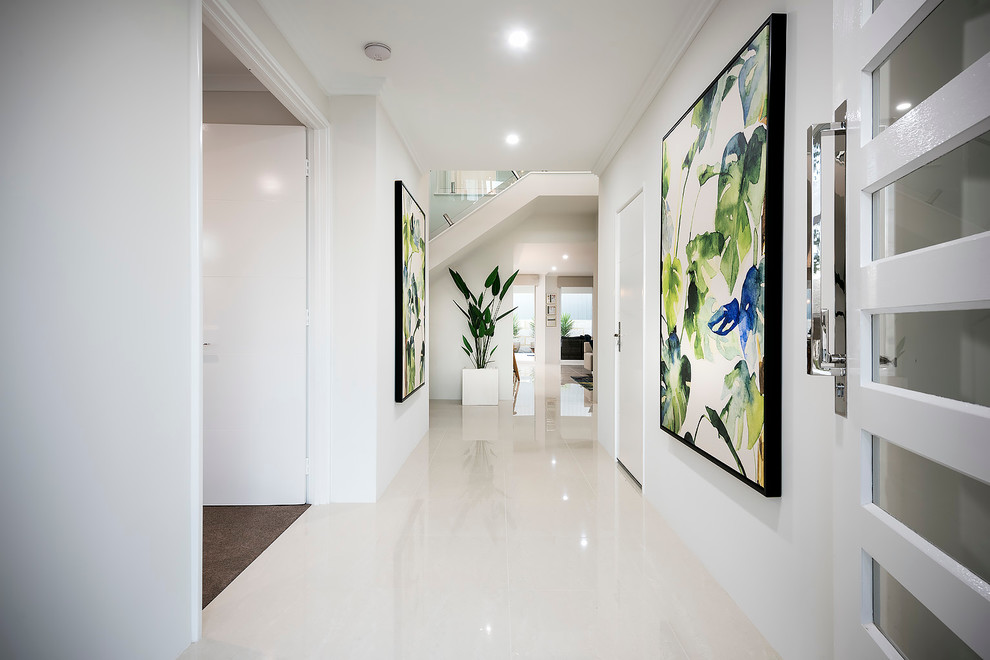 Ispirazione per un corridoio minimal di medie dimensioni con pareti bianche, pavimento con piastrelle in ceramica, una porta singola e una porta bianca