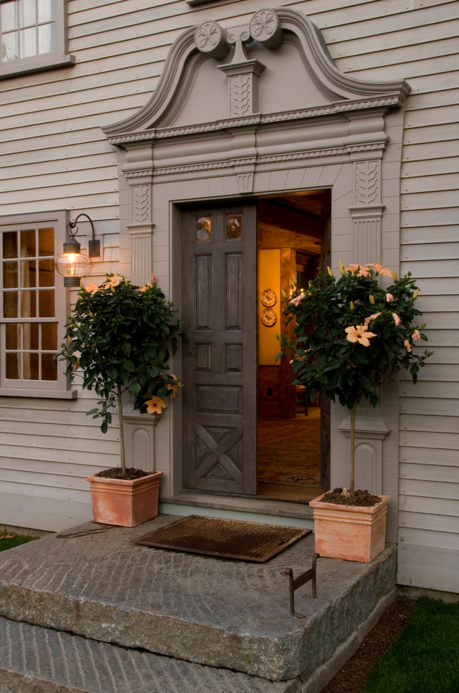 На фото: входная дверь в классическом стиле с двустворчатой входной дверью и входной дверью из темного дерева с
