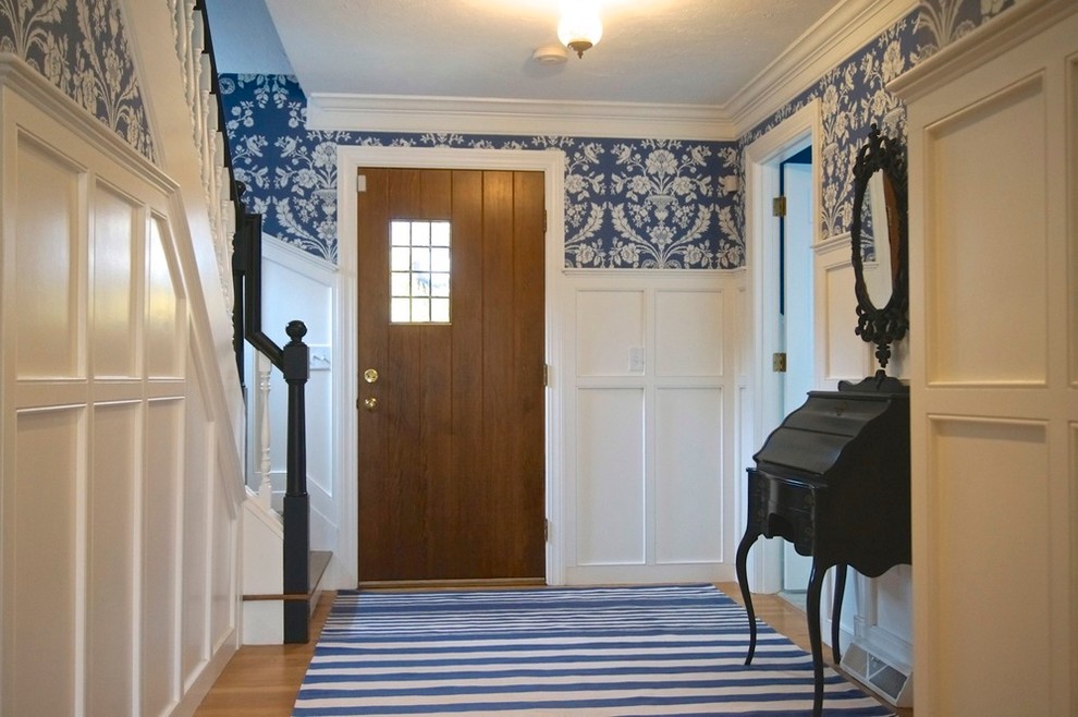Idée de décoration pour un petit hall d'entrée tradition avec un mur bleu, un sol en bois brun, une porte simple et une porte en bois brun.