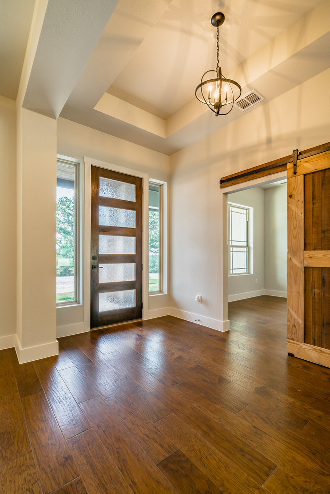 Mittelgroße Klassische Haustür mit beiger Wandfarbe, dunklem Holzboden, Einzeltür, dunkler Holzhaustür und braunem Boden in Austin