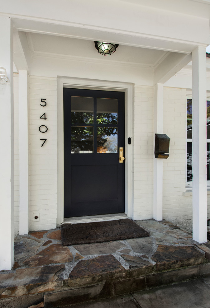 Стильный дизайн: входная дверь среднего размера в стиле кантри с белыми стенами, полом из сланца, одностворчатой входной дверью, черной входной дверью и разноцветным полом - последний тренд