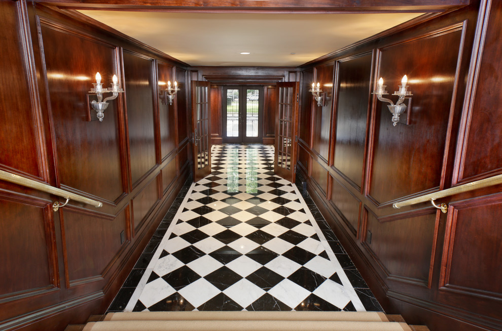 Aménagement d'un grand hall d'entrée classique avec un mur marron, un sol en marbre, une porte double et une porte en verre.
