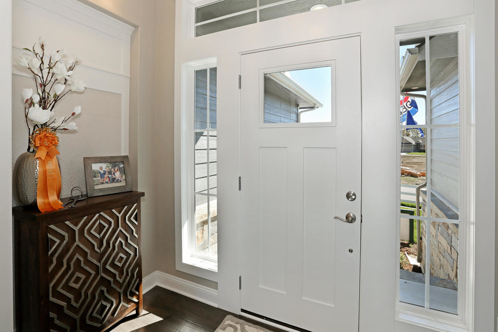 Diseño de puerta principal de estilo americano de tamaño medio con paredes blancas, suelo de madera oscura, puerta simple y puerta blanca