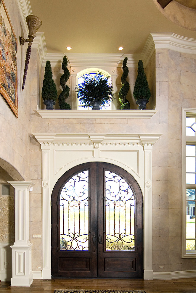 Exemple d'une grande porte d'entrée chic avec un mur beige, parquet clair, une porte double, une porte en bois foncé et un sol marron.
