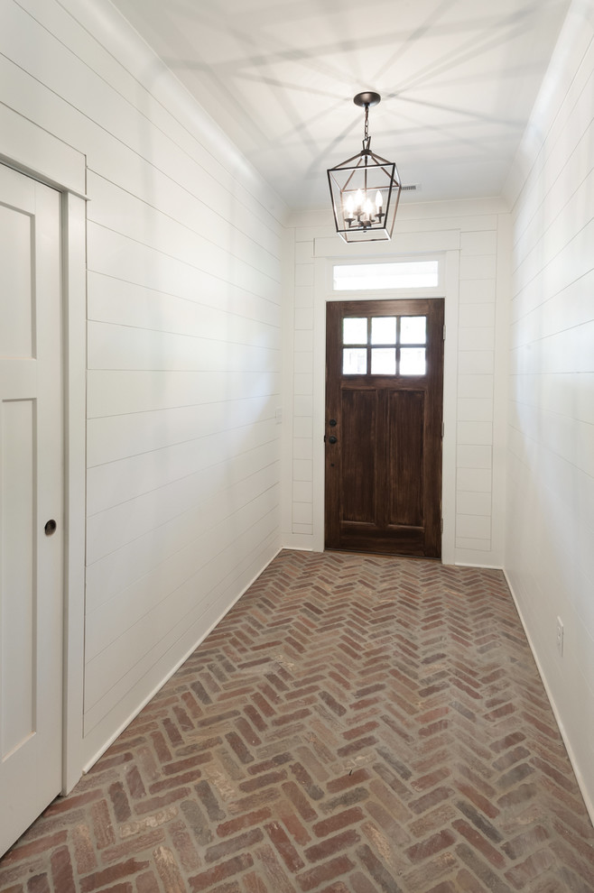 Idee per un ingresso american style di medie dimensioni con pareti bianche, pavimento in mattoni, una porta singola, una porta in legno scuro e pavimento rosso